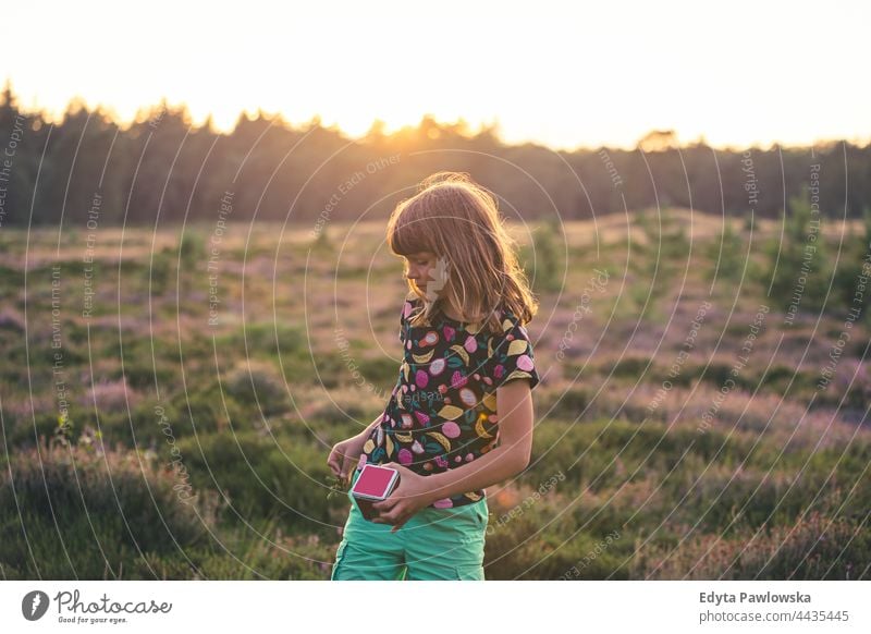 Kleines Mädchen auf einer Wiese voller Heidekraut bei Sonnenuntergang Gras Feld ländlich Landschaft Abenteuer Wildnis wild
Haare Urlaub reisen aktiv Sommerzeit