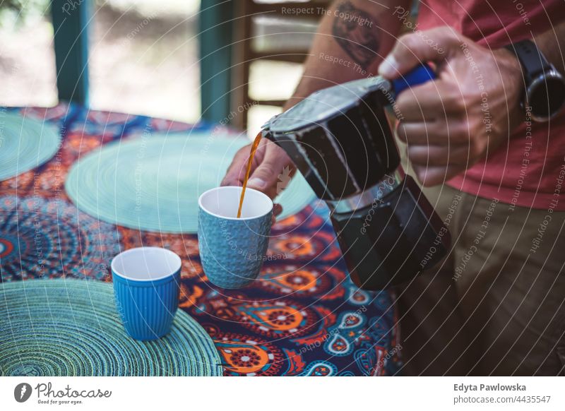 Mann gießt Kaffee aus einer Kaffeemaschine in eine Tasse Kaffeetasse Hände trinken Lebensmittel frisch Frische Gießen Barista Herstellung heimwärts Haus