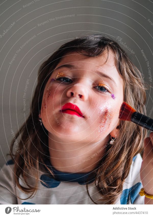 Mädchen trägt zu Hause Glitter auf das Gesicht auf Make-up bewerben Schönheit Kosmetik dekorativ achtsam Kindheit Applikator Erdbeeren Ornament Fokus sortiert