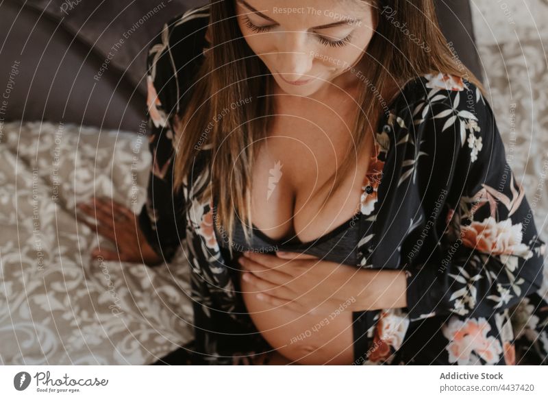 Schwangere Frau in Unterwäsche ruht sich auf dem Bett zu Hause aus schwanger vorwegnehmen mütterlich erwarten Windstille Dessous heimwärts Schwangerschaft