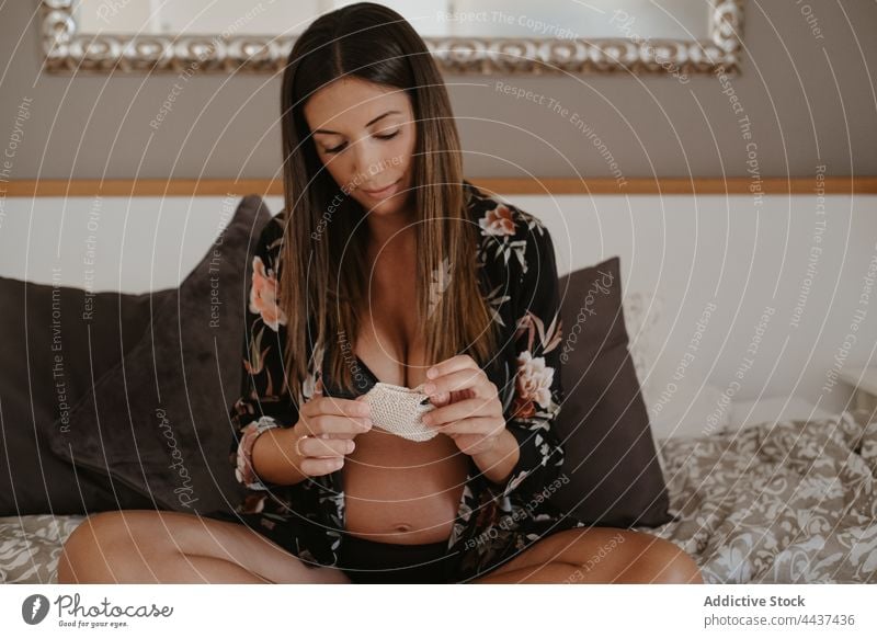 Schwangere Frau in Unterwäsche ruht sich auf dem Bett zu Hause aus schwanger vorwegnehmen Kniestrümpfe mütterlich erwarten Windstille Dessous Beine gekreuzt