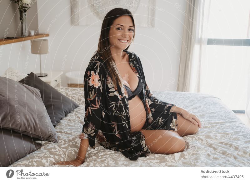 Schwangere Frau in Unterwäsche ruht sich auf dem Bett zu Hause aus schwanger vorwegnehmen mütterlich erwarten Windstille Glück Dessous heimwärts Schwangerschaft