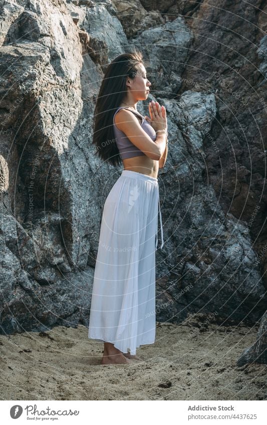 Asiatische Frau meditiert mit Namaste Hände gegen Berg Yoga meditieren Sprit Energie Wellness Vitalität üben Felsen Achtsamkeit Asana Gesunder Lebensstil atmen