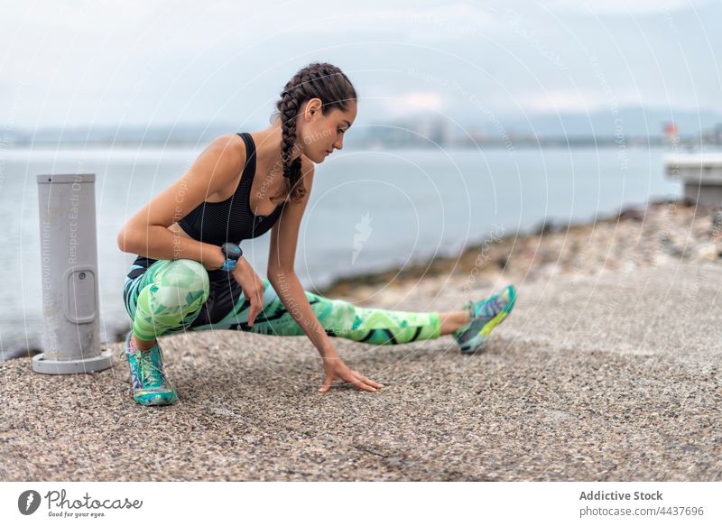 Flexible Sportlerin streckt die Beine beim Training Ausfallschritt Übung Dehnung Athlet Stauanlage beweglich Aufwärmen Frau Seitenlonge üben Fitness Vitalität