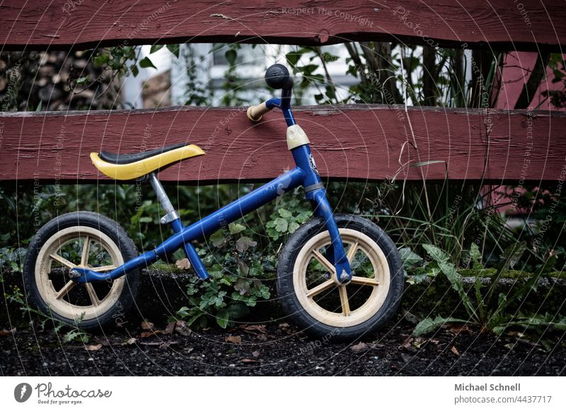 Altes Laufrad am Zaun Kind Kindheit Außenaufnahme Bewegung Kleinkind Fahrrad Spielen früher vergangen Vergangenheit Rückblick Sehnsucht melancholisch
