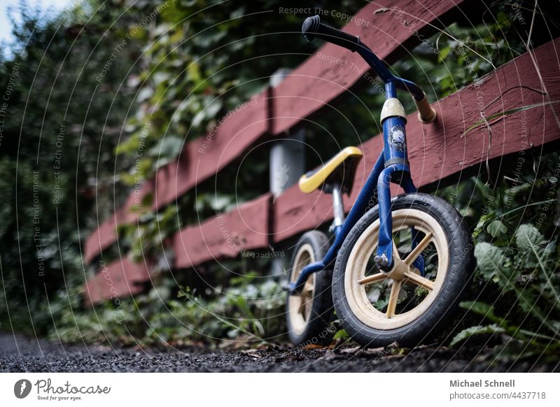 Altes Laufrad am Zaun Kind Kindheit Außenaufnahme Bewegung Kleinkind Fahrrad Spielen früher vergangen Vergangenheit Rückblick Sehnsucht melancholisch