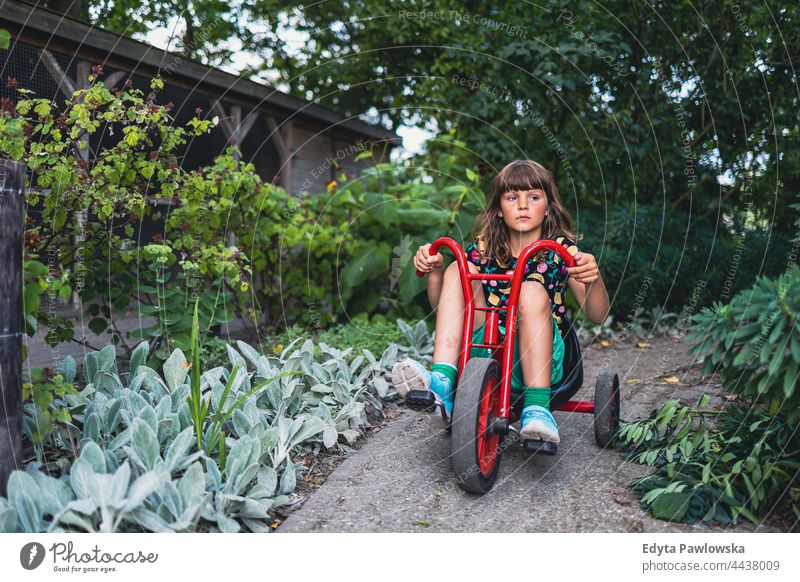 Kleines Mädchen fährt mit dem Fahrrad im Park Fahrradfahren Reiten Garten Urlaub aktiv Abenteuer Sommerzeit Tag Freiheit Feiertag genießend außerhalb ernst