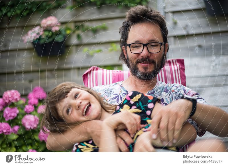 Vater spielt mit seiner Tochter im Garten echte Menschen authentisch Zusammensein heimwärts Eltern Liebe Urlaub aktiv Sommerzeit Tag Feiertag Kribbeln kitzelnd