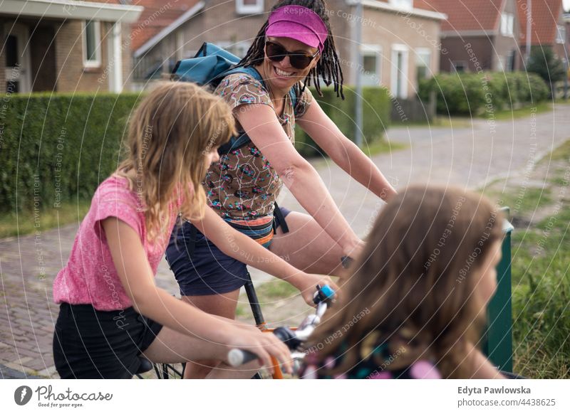 Mutter mit ihren Kindern auf Fahrrädern echte Menschen authentisch Eltern Lächeln Ausdruck Liebe Familie Tochter holländisch Niederlande Fahrrad Fahrradfahren