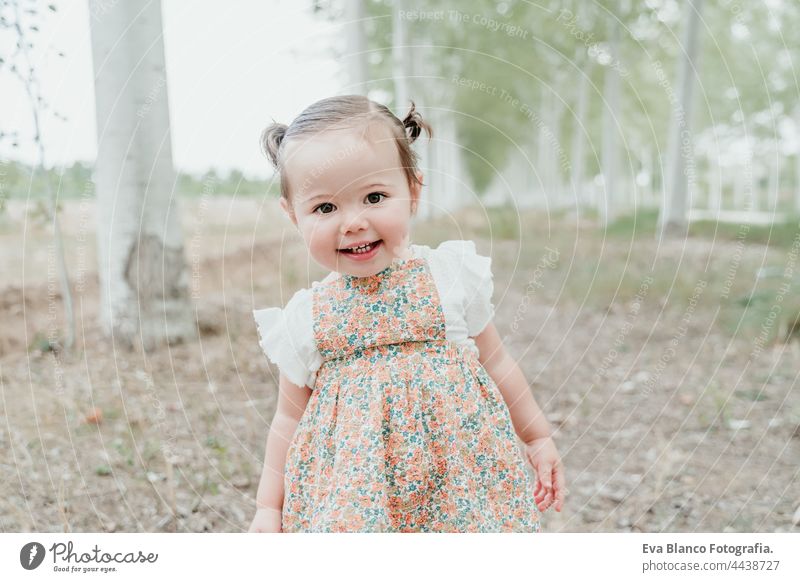schönes Porträt von Baby-Mädchen mit Spaß im Freien in Bäumen Weg. Kinder, Spaß und Natur Konzept Wald Glück Kindheit Lächeln laufen Kaukasier Spanien Kleid