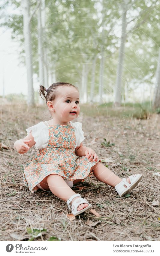 glückliches Baby-Mädchen hat Spaß im Freien in den Bäumen Weg. Kinder, Spaß und Natur Konzept Wald Glück Kindheit Lächeln laufen Kaukasier Spanien Kleid