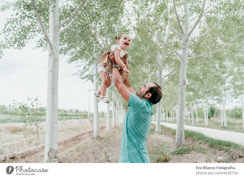 glücklicher Vater und Tochter spielen im Freien im Pfad Bäume. Familie, Spaß und Natur Konzept kleines Mädchen Spielen Wald Liebe Zusammensein