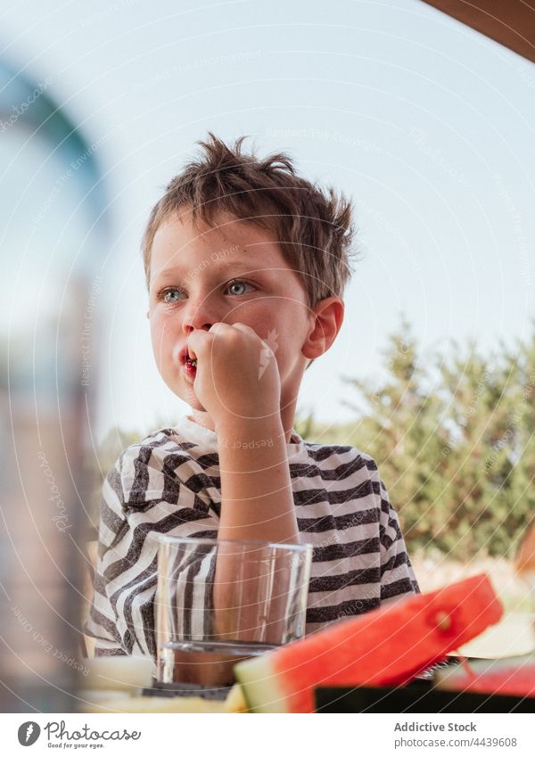 Junge isst Wassermelone im Hinterhof im Sommer Kind essen frisch süß bezaubernd Lebensmittel niedlich Kindheit wenig geschmackvoll lecker reif sitzen Gesundheit