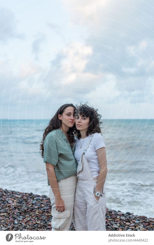 Homosexuelles Frauenpaar umarmt sich am Meeresufer Paar Umarmen lesbisch Partnerschaft Liebe Seelenverwandter romantisch wolkig Porträt Himmel Freundin MEER