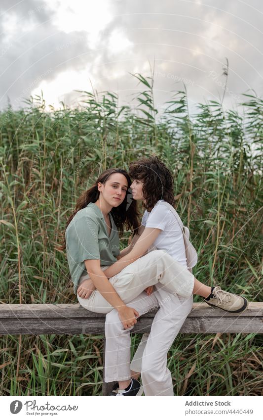 Lesbisches Paar interagiert am Zaun gegen Pflanzen Freundin gleichgeschlechtlich Partnerschaft Liebe romantisch Zeit verbringen Wochenende interagieren