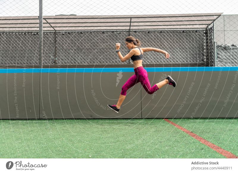 Aktive Frau springt beim Training im Stadion hoch springen dynamisch Sprung Kraft Fitness aktiv Sportlerin Energie über der Erde sich[Akk] bewegen