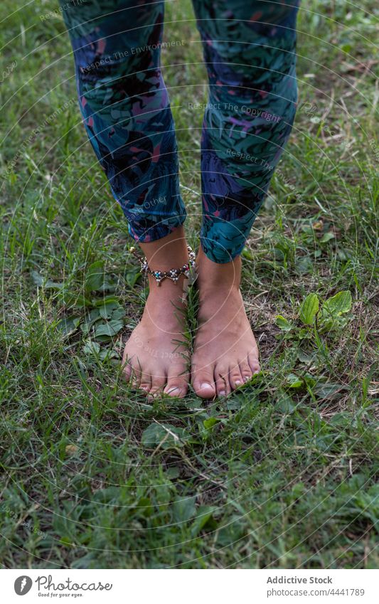Barfuß Frau steht auf grünem Gras im Park Natur Harmonie Windstille ruhig jung stehen natürlich Umwelt Tageslicht Accessoire Dame üben friedlich Yoga Gesundheit