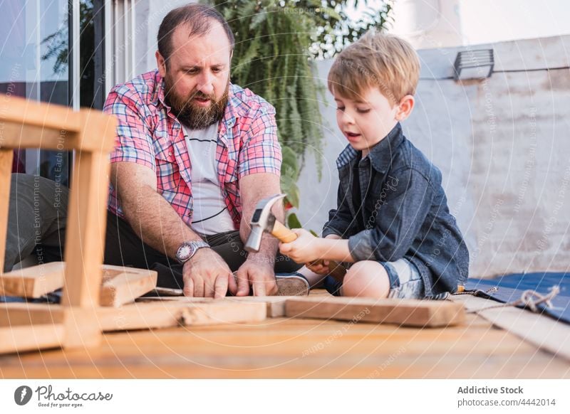 Vater erklärt dem Jungen, wie man mit Holz arbeitet Papa Sohn Holzarbeiten erklären zeigen Hammer Handarbeit diy Basteln achtsam Mann Zeit verbringen reden