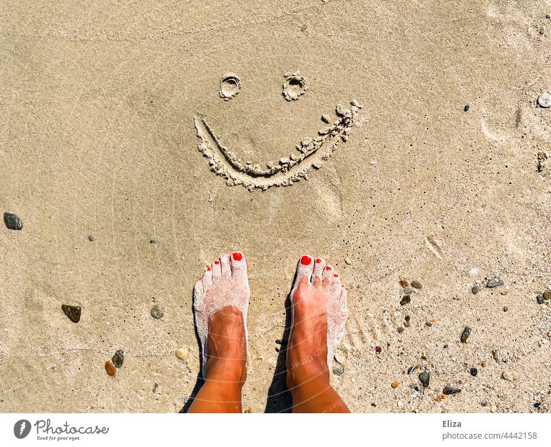 Sandige Füße am Strand vor einem in den Sand gemalten lächelnden Smiley gute Laune Urlaub Freude Sommer Ferien & Urlaub & Reisen Zufriedenheit Urlaubsstimmung
