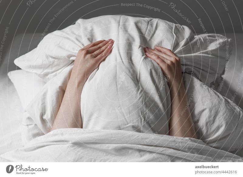 Frau im Bett versteckt Gesicht unter Kissen Kopfkissen müde Langschläfer Spätaufsteher verstecken schlafen unkenntlich Person Frustration Geräusch Angst Stress