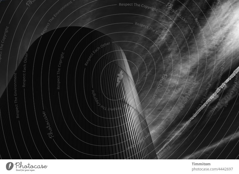 Glänzender Energiespeicher und Linien im Himmel Turm Oberfläche glänzend Wolken Kondensstreifen Sonnenlicht Menschenleer dramatisch Technik Dänemark