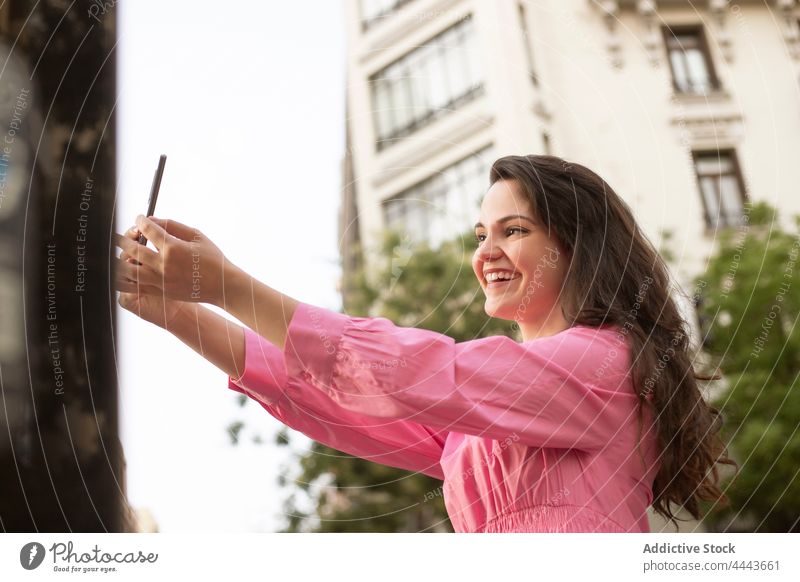 Anonyme Frau macht Selfie mit Smartphone auf der Straße Lächeln fotografieren benutzend Anschluss online Glück heiter Anzeige digital Großstadt Freude Mobile