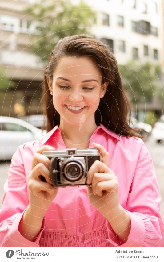 Junge lächelnde Frau, die ein Foto mit einer alten Kamera macht altehrwürdig fotografieren Fotoapparat Moment klassisch einfangen Fokus Linse retro Gedächtnis