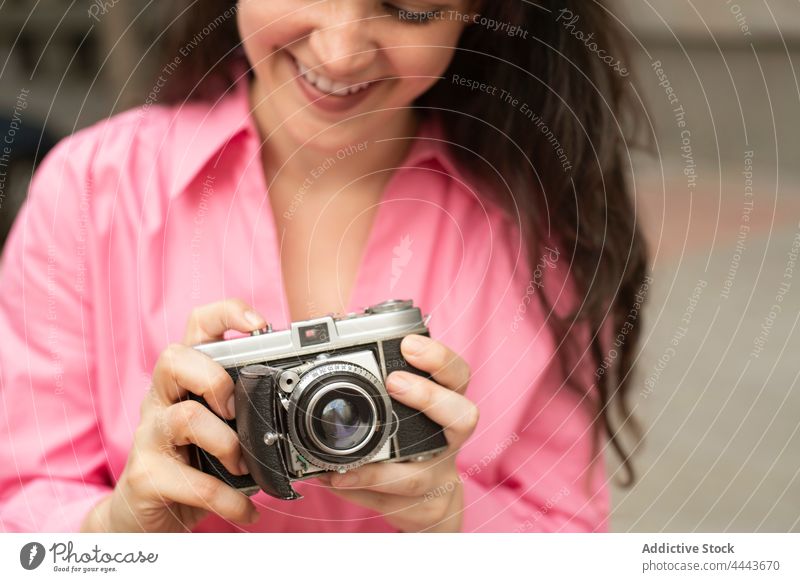 Junge Frau fotografiert mit einer alten Kamera altehrwürdig fotografieren Fotoapparat Moment klassisch einfangen Fokus Linse retro Gedächtnis Gebäude Straße