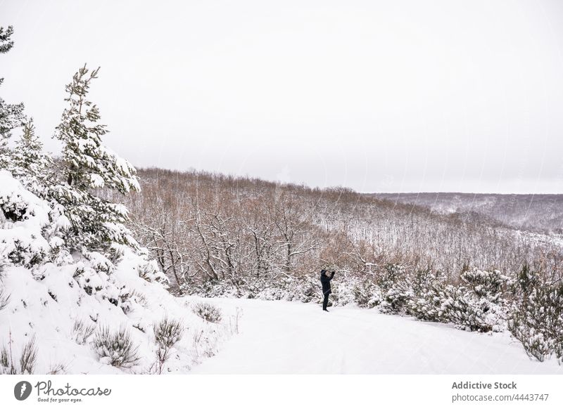 Reisende, die auf einem verschneiten Hügel im Winter stehen Person Schnee Natur Landschaft Berghang Reisender Wanderer Hochland Handy kalt Baum Fotograf Bild