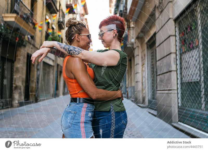 Coole glückliche homosexuelle Freundinnen im Moment des Kusses auf der Straße Paar Umarmen Partnerschaft Liebe Tattoo lgbt Frauen Straßenbelag Achtsamkeit