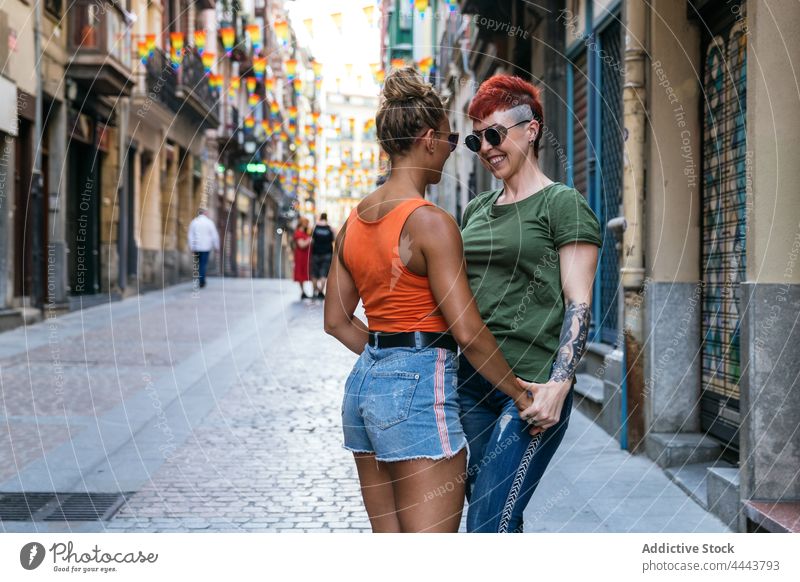 Coole glückliche homosexuelle Freundinnen im Moment des Kusses auf der Straße Paar Umarmen Partnerschaft Liebe Tattoo lgbt Frauen Straßenbelag Achtsamkeit