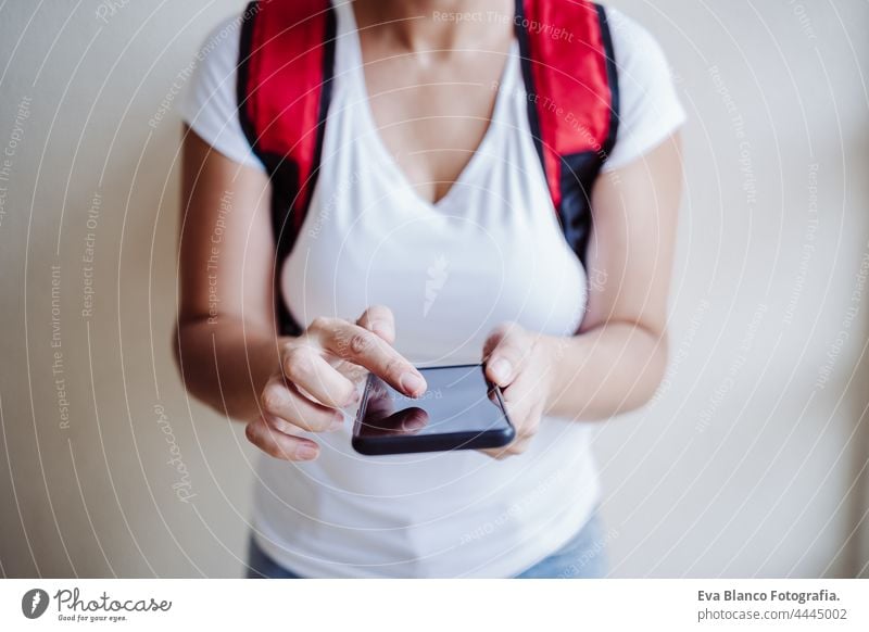 unerkennbar Fahrer Frau trägt roten Rucksack liefern Essen, Überprüfung der Bestellung mit Smartphone, während auf der Straße in der Stadt stehen. Konzept eines Lieferdienstes. Nachhaltiger Transport