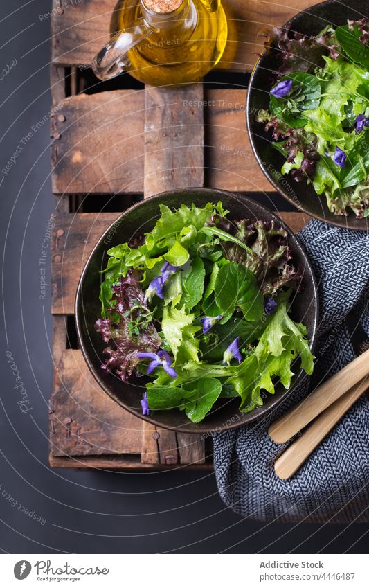 Leckerer Salat und Wildblumensalat in Schalen auf dunklem Hintergrund Salatbeilage gesunde Ernährung Vegetarier Gemüse natürlich frisch Erdöl lecker Vitamin