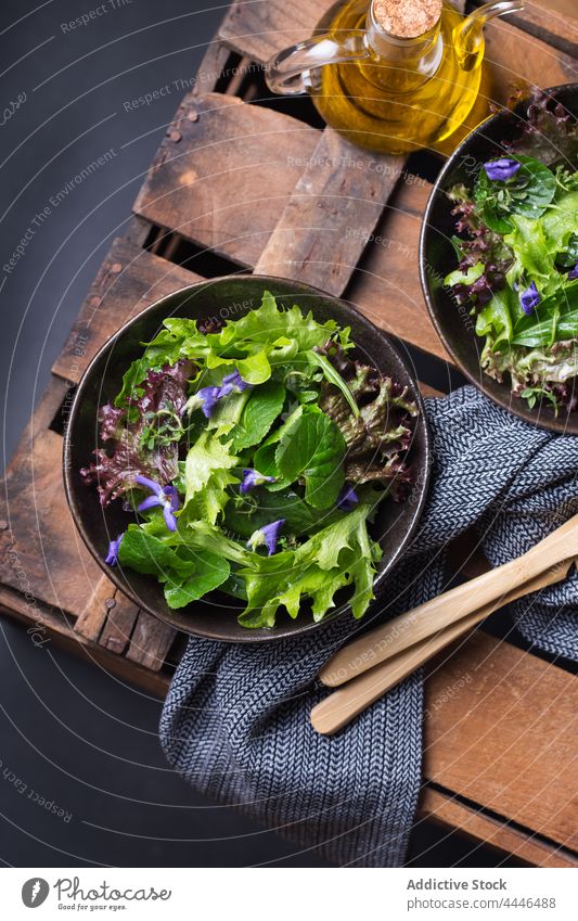 Leckerer Salat und Wildblumensalat in Schalen auf dunklem Hintergrund Salatbeilage gesunde Ernährung Vegetarier Gemüse natürlich frisch Erdöl lecker Vitamin