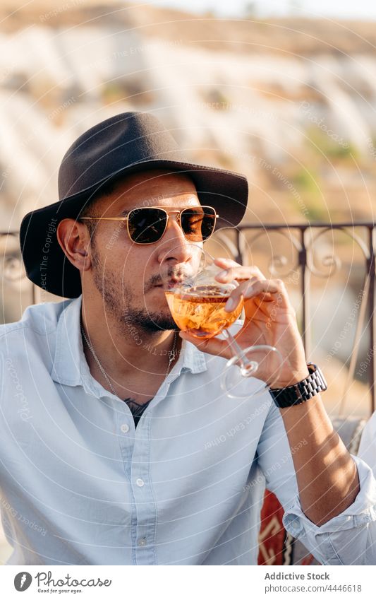Stilvoller Mann trinkt Aperol Spritz in einer Bar Aperol-Spritz Cocktail cool Alkohol trinken kalt Kälte männlich Getränk sich[Akk] entspannen Vollbart jung