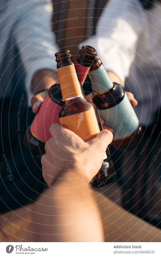 Eine Gruppe von Freunden stößt mit Bierflaschen an Männer Frau Klirren Flasche jubelt Treffpunkt sich[Akk] sammeln Bar männlich Zusammensein Pub Freundschaft