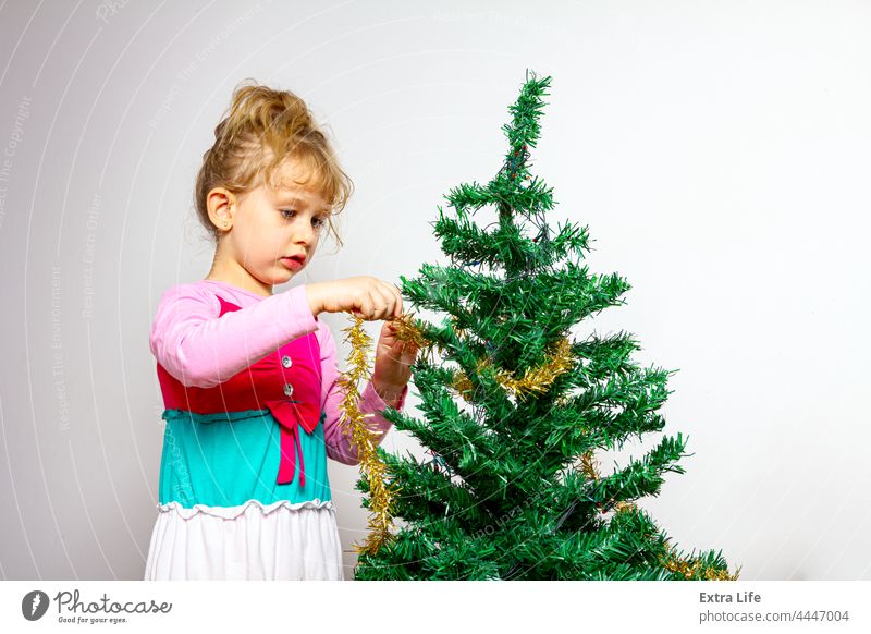 Kind Mädchen arrangiert Ornament Dekoration auf künstlichen Weihnachtsbaum bezaubernd einrichten Versammlung blond Kaukasier Kindheit Weihnachten Konifere Kurve
