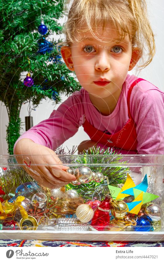 Kind Mädchen arrangiert Ornament Dekoration auf künstlichen Weihnachtsbaum einrichten Versammlung Kasten Kaukasier Kindheit wählen wählte Weihnachten Konifere