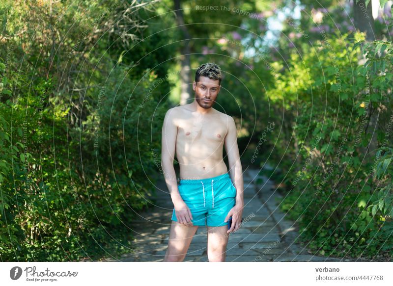 Hemdloser kaukasischer junger Mann in türkisfarbenen Shorts in einem Park im Sommer Tänzer schwul Tanzen Glück Lifestyle Person Stolz Hintergrund Identität