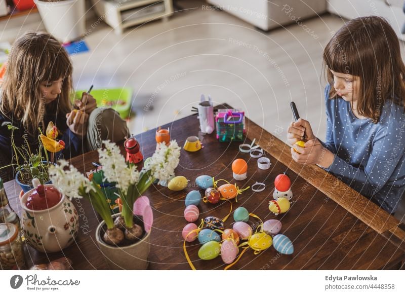 Zwei Mädchen bemalen Ostereier zu Hause im Innenbereich dekorierend Kunst Vorbereitung Dekoration & Verzierung Hobby Kunsthandwerk farbig festlich jagen feiern