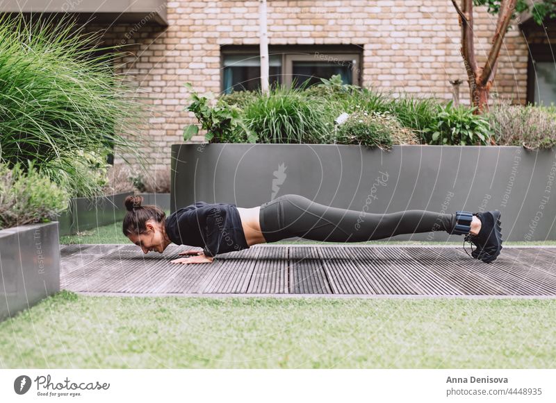 Junge Frau beim Yoga urban online Smartphone psychische Gesundheit Wellness einfache Freuden Meditation Entfernte Workouts Garten Von zu Hause aus trainieren