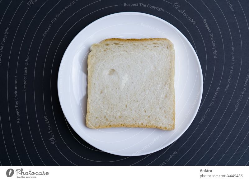 Eine Scheibe Toast auf einem weißen Teller, schwarzer Hintergrund Brot Zuprosten Top Ansicht Belegtes Brot vereinzelt geröstet Lebensmittel Frühstück oben Snack
