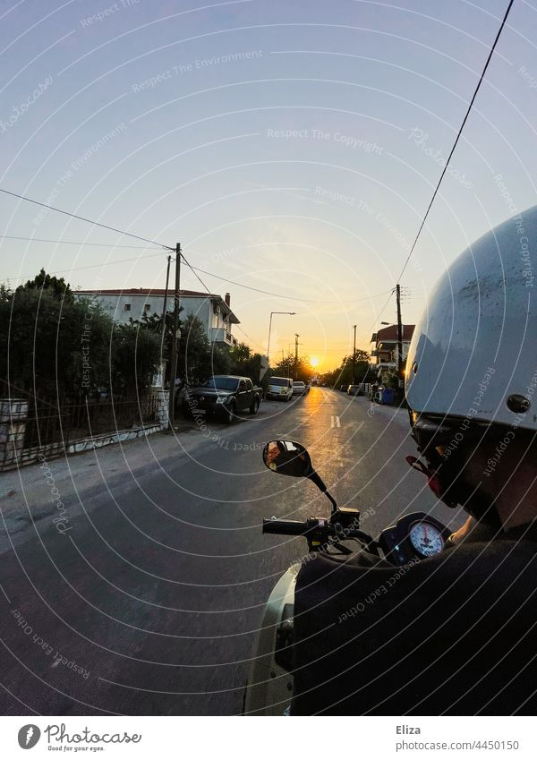 Ein Mann mit Helm fährt auf einem Quad dem Sonnenuntergang entgegen Abenteuer fahren Freiheit Sommer Straße motorisiert Fahrzeug Ortschaft Ausflug Ausland