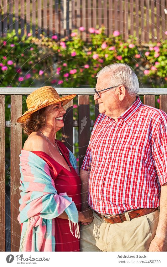Älteres fröhliches Paar steht in der Nähe eines Holzzauns Lachen Senior Glück romantisch Partnerschaft genießen Zaun Natur Landschaft Spaß Mann Frau