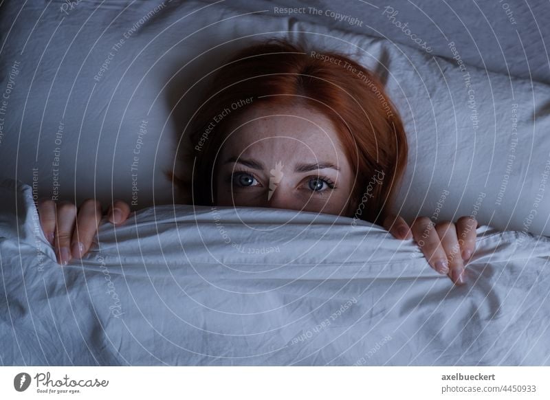 schlaflose Frau im Bett liegend, die sich nachts unter der Bettdecke versteckt schlafen Nacht Alptraum Mädchen Schlafstörung Gesicht müde Person Frustration