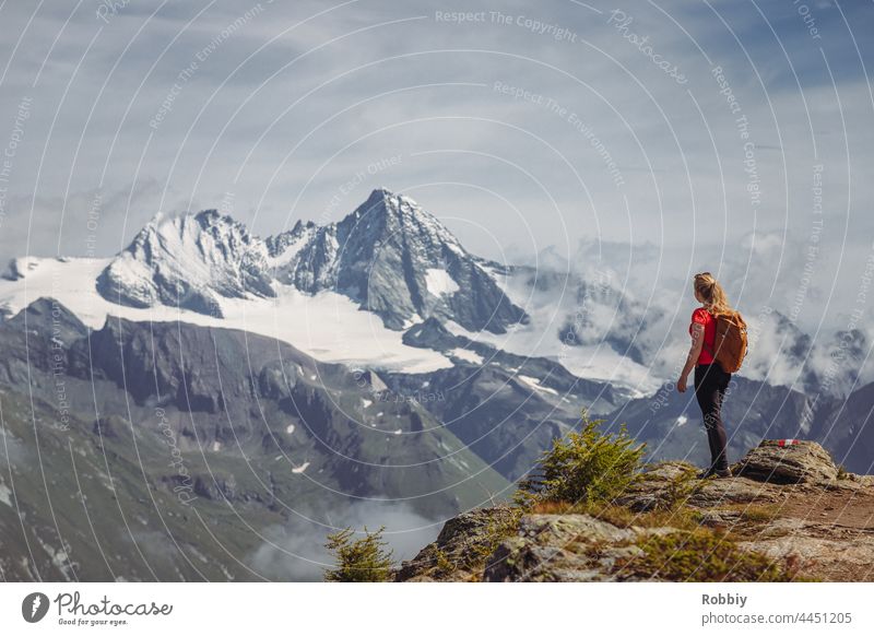 Junge Frau mit Rucksack blickt auf den Berg Großglockner in Osttirol Alpen Wandern Gipfel Urlaub junge Frau Gebirge Österreich Wanderung Ausblick Aussichtspunkt