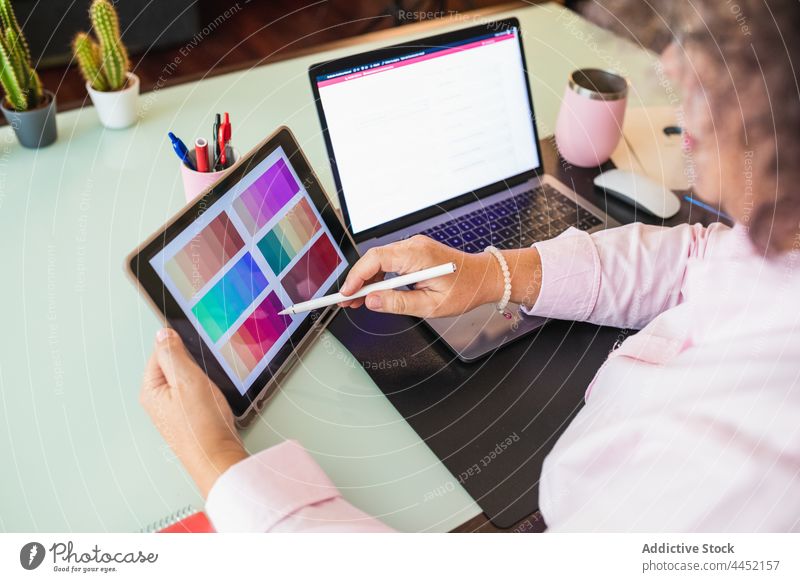 Crop-Geschäftsfrau zeigt Farbpalette auf Tablet während Videoanruf Palette Farbe Tablette Laptop Senior erklären Touchscreen Büro benutzend Apparatur Frau Gerät