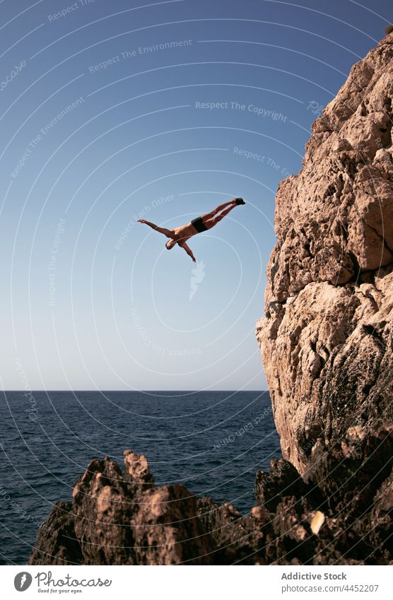 Sportler springt vom Felsen ins Meer mit Horizont springen Fliege MEER Energie Adrenalin extrem Himmel Mann sportlich ausdehnen Trick aktiv dynamisch furchtlos