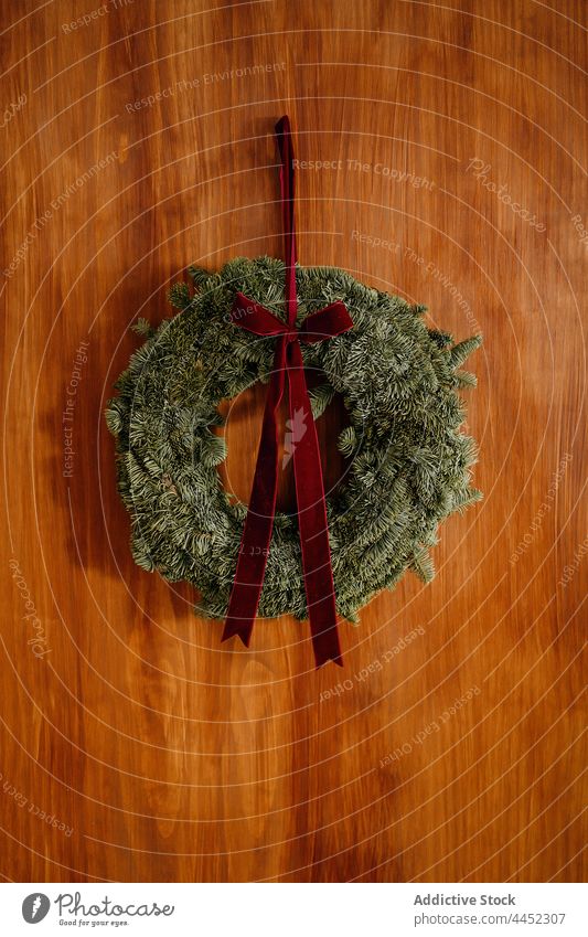 Weihnachtskranz an einer Holzwand Weihnachten Totenkranz Dekoration & Verzierung feiern nadelhaltig Tanne Schleife festlich hängen dekorativ Design Wand