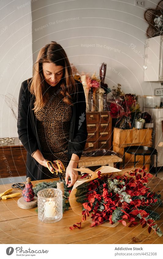 Eine Floristin macht einen Blumenstrauß in einem Floristikstudio Frau Blumenhändler einrichten geblümt Werkstatt Arbeit Atelier Blütezeit Arbeitsplatz